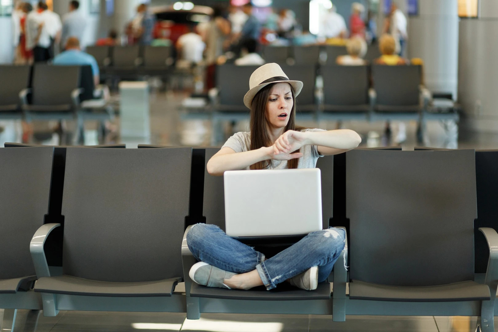 Persona esperando en el aeropuerto revisando su vuelo.